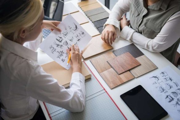 Deux professionnelles analysent des croquis de mobilier et des dalles de parquet en bois lors d'une réunion de conception assistée par l'IA.